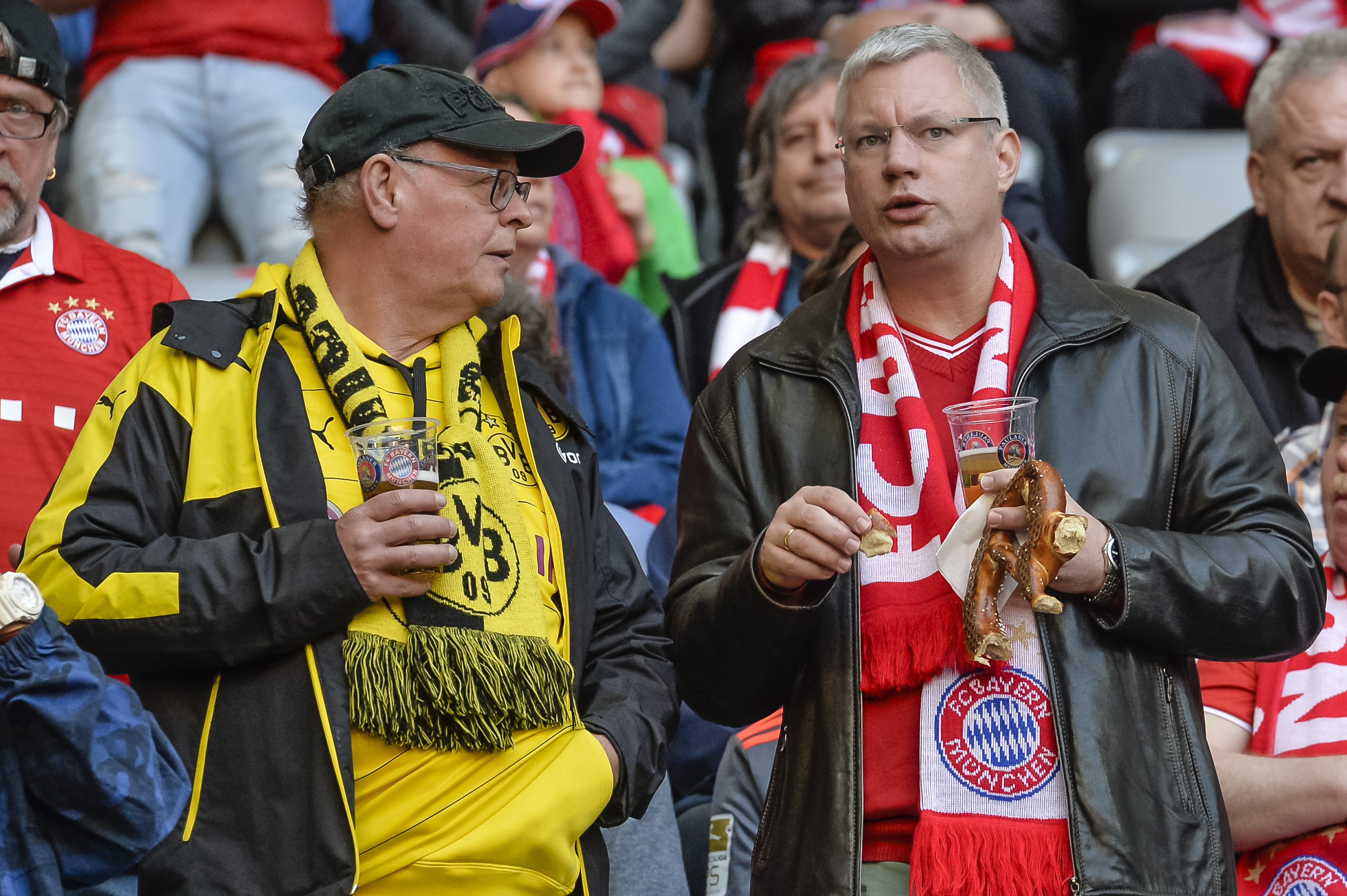 A Dortmund and a Bayern Munich fan chat prior to the German first division Bundesliga football match FC Bayern Munich v BVB Borussia Dortmund in Munich, southern Germany, on April 8, 2017. / AFP PHOTO / Guenter SCHIFFMANN / RESTRICTIONS: DURING MATCH TIME: DFL RULES TO LIMIT THE ONLINE USAGE TO 15 PICTURES PER MATCH AND FORBID IMAGE SEQUENCES TO SIMULATE VIDEO. == RESTRICTED TO EDITORIAL USE == FOR FURTHER QUERIES PLEASE CONTACT DFL DIRECTLY AT + 49 69 650050
        (Photo credit should read GUENTER SCHIFFMANN/AFP/Getty Images)