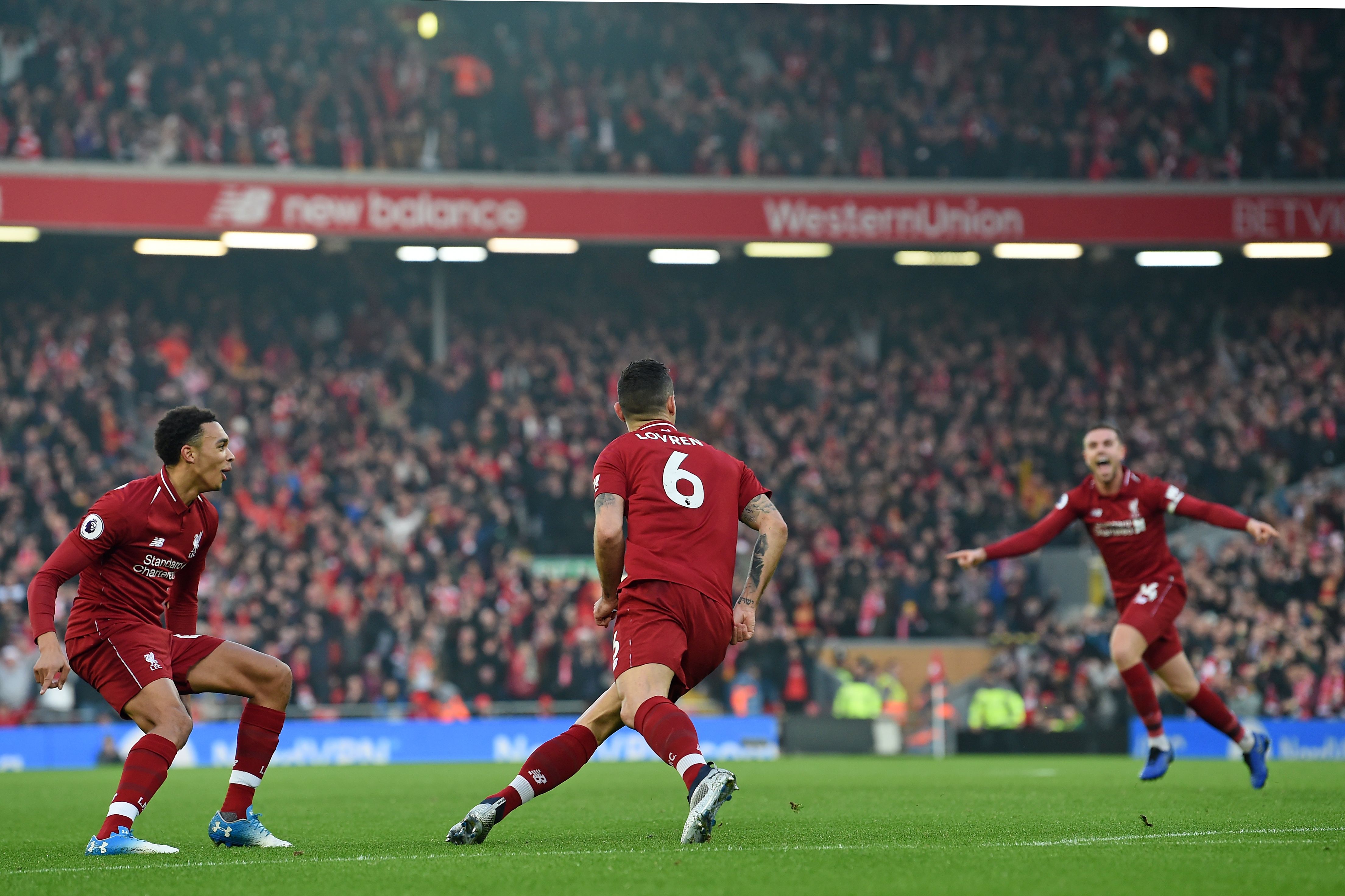 Liverpool's Croatian defender Dejan Lovren (C) celebrates with Liverpool's English defender Trent Alexander-Arnold (L) and Liverpool's English midfielder Jordan Henderson (R) after scoring the opening goal of the English Premier League football match between Liverpool and Newcastle United at Anfield in Liverpool, north west England on December 26, 2018. (Photo by Paul ELLIS / AFP) / RESTRICTED TO EDITORIAL USE. No use with unauthorized audio, video, data, fixture lists, club/league logos or 'live' services. Online in-match use limited to 120 images. An additional 40 images may be used in extra time. No video emulation. Social media in-match use limited to 120 images. An additional 40 images may be used in extra time. No use in betting publications, games or single club/league/player publications. /         (Photo credit should read PAUL ELLIS/AFP/Getty Images)