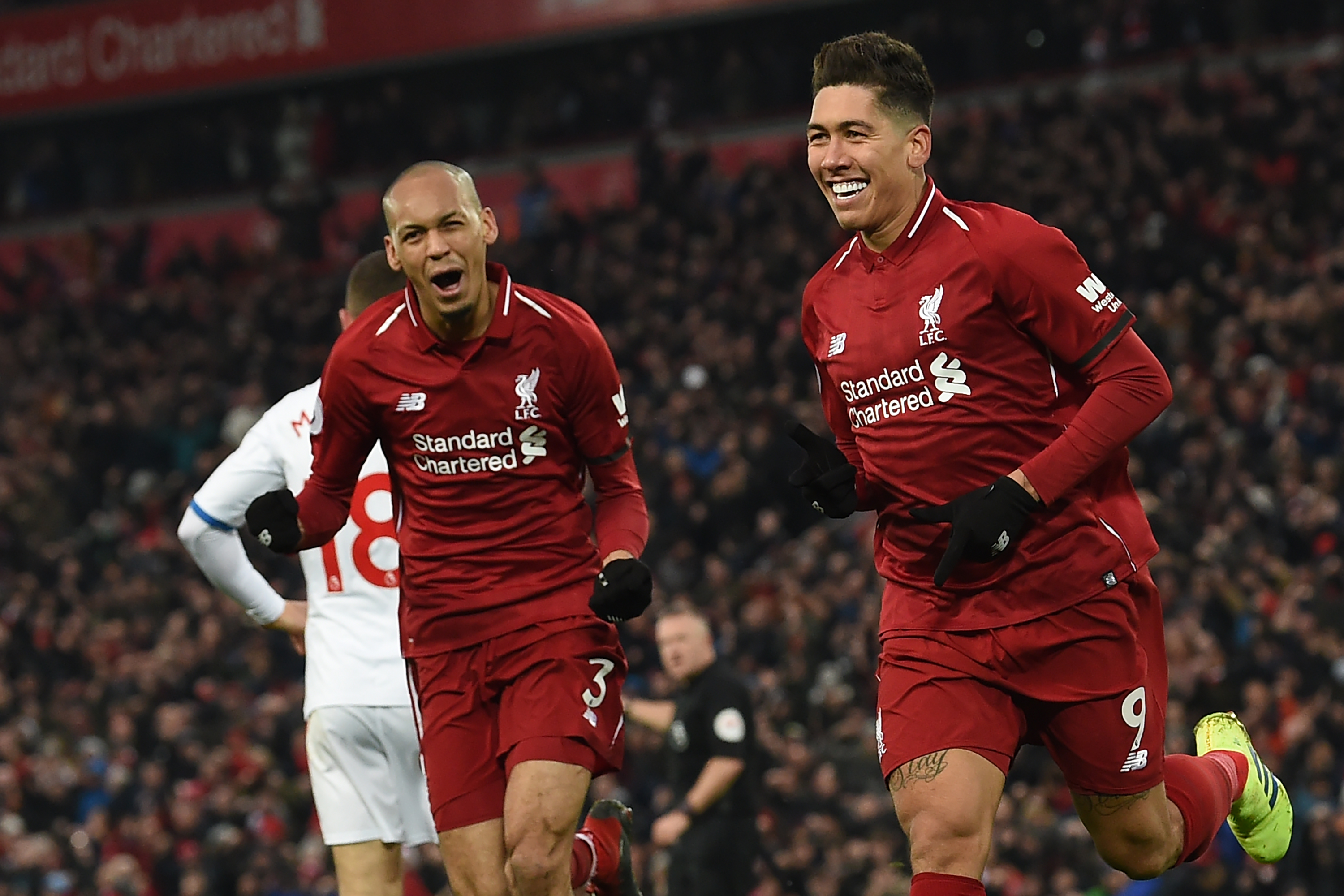 Liverpool's Brazilian midfielder Roberto Firmino (R) celebrates with Liverpool's Brazilian midfielder Fabinho (L) after scoring their second goal during the English Premier League football match between Liverpool and Crystal Palace at Anfield in Liverpool, north west England on January 19, 2019. (Photo by Paul ELLIS / AFP) / RESTRICTED TO EDITORIAL USE. No use with unauthorized audio, video, data, fixture lists, club/league logos or 'live' services. Online in-match use limited to 120 images. An additional 40 images may be used in extra time. No video emulation. Social media in-match use limited to 120 images. An additional 40 images may be used in extra time. No use in betting publications, games or single club/league/player publications. /         (Photo credit should read PAUL ELLIS/AFP/Getty Images)