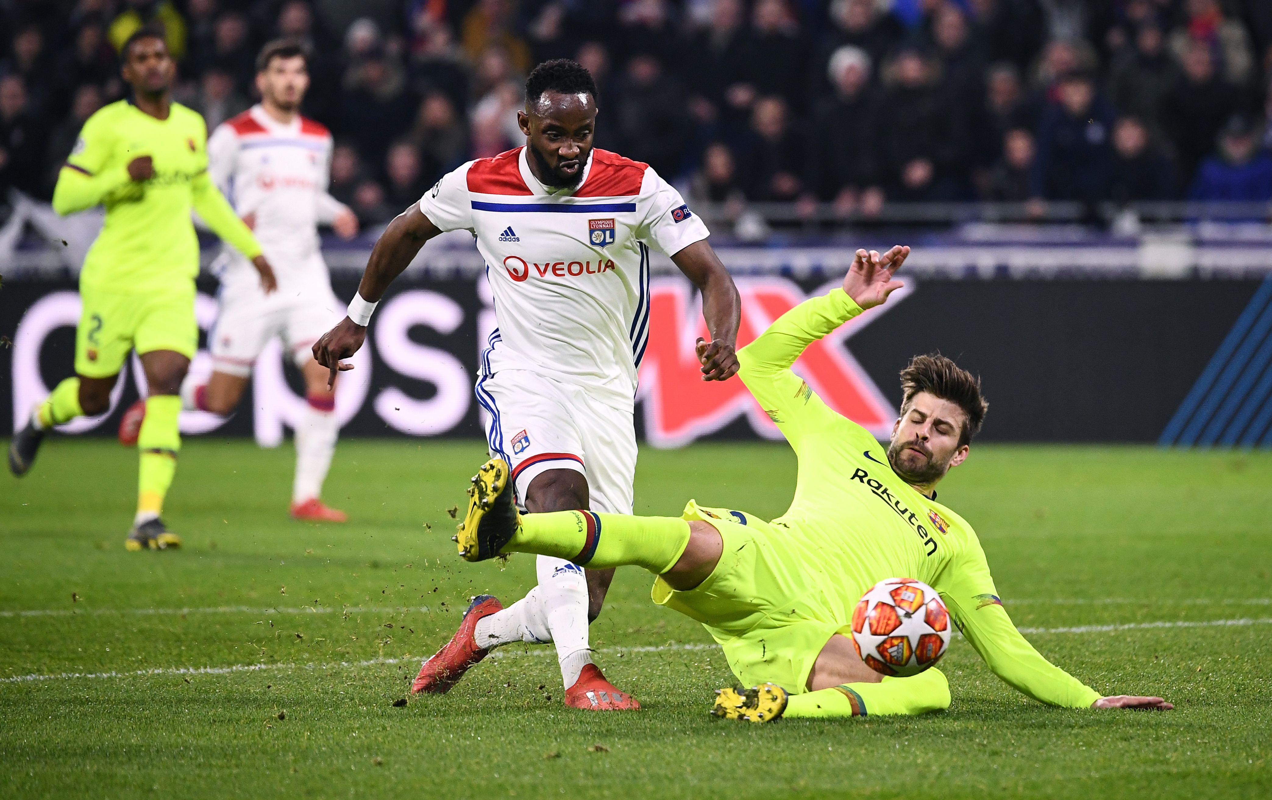 Lyon's French forward Moussa Dembele (L) shoots the ball next to Barcelona's Spanish defender Gerard Pique (R) during the UEFA Champions League round of 16 first leg football match between Lyon (OL) and FC Barcelona on February 19, 2019, at the Groupama Stadium in Decines-Charpieu, central-eastern France. (Photo by FRANCK FIFE / AFP)        (Photo credit should read FRANCK FIFE/AFP/Getty Images)