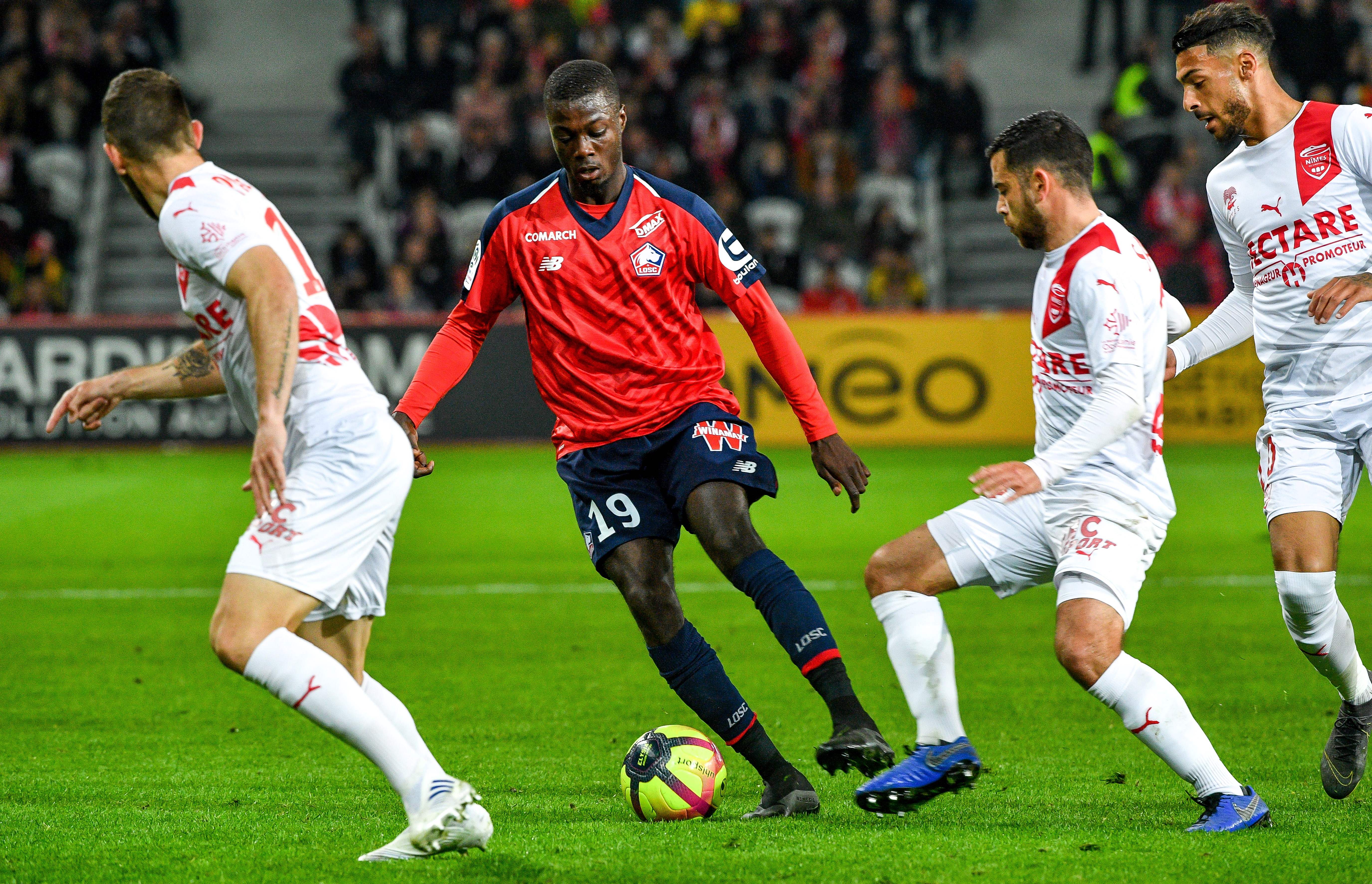 Lille's Ivorian forward Nicolas Pepe (C-L) fights for the ball with Nîmes' French midfielder Teji Savanier (C-R)  during the French L1 football match between Lille LOSC and Nimes Olympique at the Pierre-Mauroy Stadium in Villenueve d'Ascq, northern France on April 28, 2019. (Photo by PHILIPPE HUGUEN / AFP)        (Photo credit should read PHILIPPE HUGUEN/AFP/Getty Images)