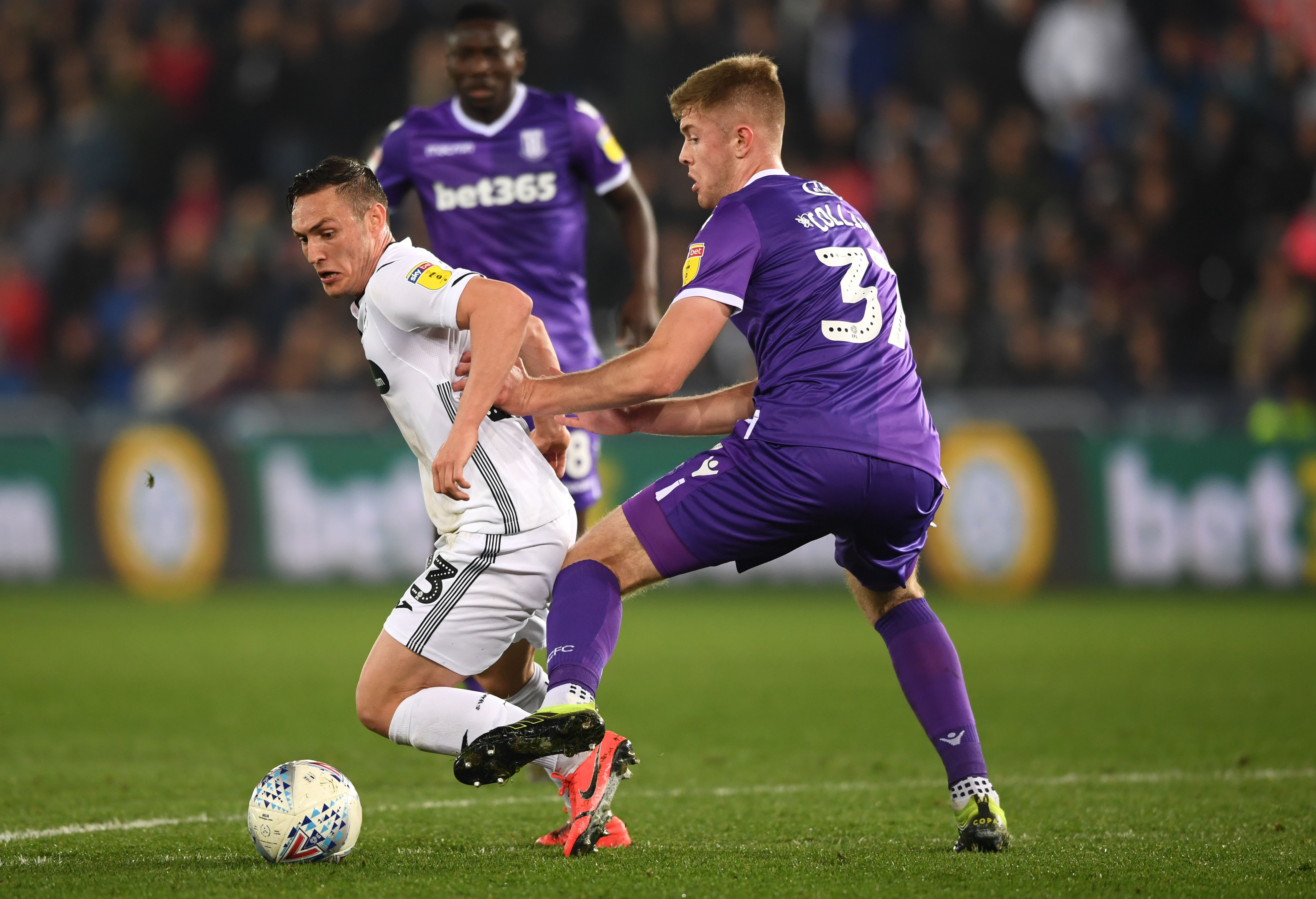 SWANSEA, WALES - APRIL 09: Swansea player Connor Roberts is challenged by Nathan Collins during the Sky Bet Championship match between Swansea City and Stoke City at Liberty Stadium on April 09, 2019 in Swansea, Wales. (Photo by Stu Forster/Getty Images)