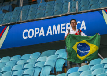 PORTO ALEGRE, BRAZIL - JUNE 15:  A fan of Peru holds a flag of Brazil during the Copa America Brazil 2019 Group A match between Venezuela and Peru during at Arena do Gremio stadium on June 15, 2019, in Porto Alegre, Brazil. (Photo by Alessandra Cabral/Getty Images)