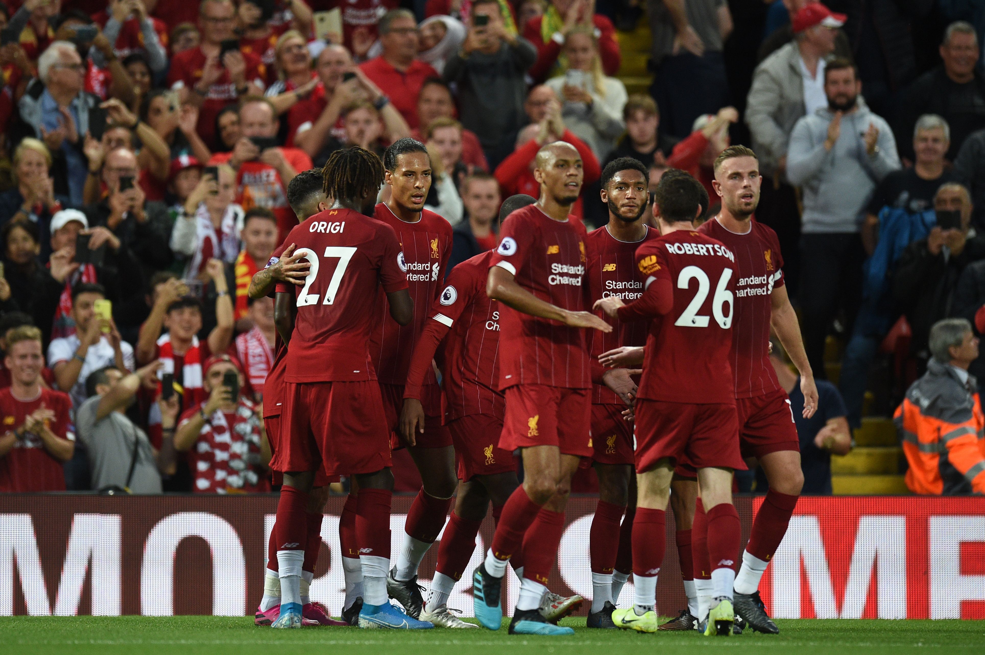 Liverpool's Dutch defender Virgil van Dijk (C)celebrates with teammates after he scores the team's third goal during the English Premier League football match between Liverpool and Norwich City at Anfield in Liverpool, north west England on August 9, 2019. (Photo by Oli SCARFF / AFP) / RESTRICTED TO EDITORIAL USE. No use with unauthorized audio, video, data, fixture lists, club/league logos or 'live' services. Online in-match use limited to 120 images. An additional 40 images may be used in extra time. No video emulation. Social media in-match use limited to 120 images. An additional 40 images may be used in extra time. No use in betting publications, games or single club/league/player publications. /         (Photo credit should read OLI SCARFF/AFP/Getty Images)