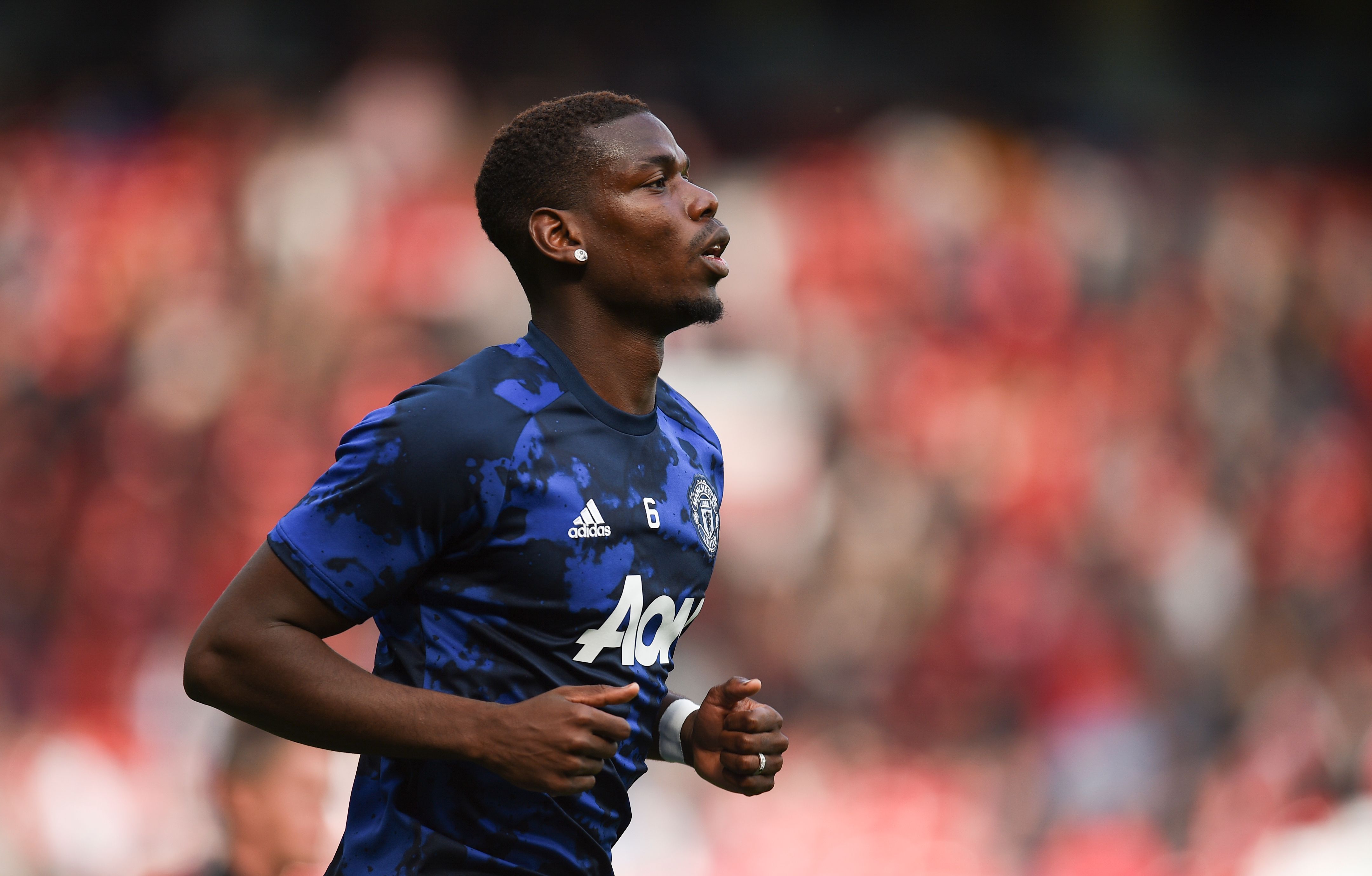 Manchester United's French midfielder Paul Pogba warms up for the English Premier League football match between Manchester United and Chelsea at Old Trafford in Manchester, north west England, on August 11, 2019. (Photo by Oli SCARFF / AFP) / RESTRICTED TO EDITORIAL USE. No use with unauthorized audio, video, data, fixture lists, club/league logos or 'live' services. Online in-match use limited to 120 images. An additional 40 images may be used in extra time. No video emulation. Social media in-match use limited to 120 images. An additional 40 images may be used in extra time. No use in betting publications, games or single club/league/player publications. /         (Photo credit should read OLI SCARFF/AFP/Getty Images)