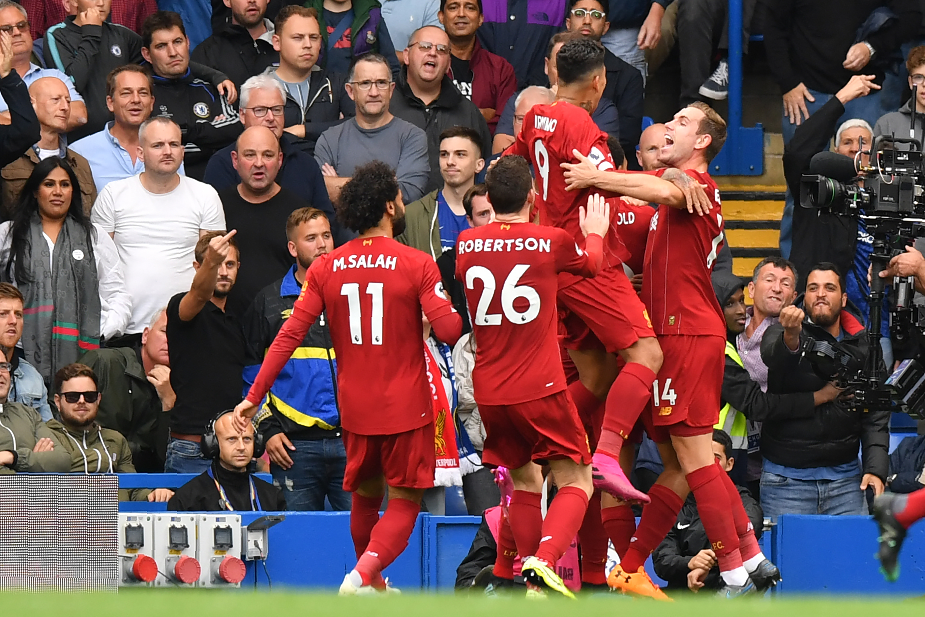 Liverpool players celebrate their first goal during the English Premier League football match between Chelsea and Liverpool at Stamford Bridge in London on September 22, 2019. (Photo by OLLY GREENWOOD / AFP) / RESTRICTED TO EDITORIAL USE. No use with unauthorized audio, video, data, fixture lists, club/league logos or 'live' services. Online in-match use limited to 120 images. An additional 40 images may be used in extra time. No video emulation. Social media in-match use limited to 120 images. An additional 40 images may be used in extra time. No use in betting publications, games or single club/league/player publications. /         (Photo credit should read OLLY GREENWOOD/AFP/Getty Images)