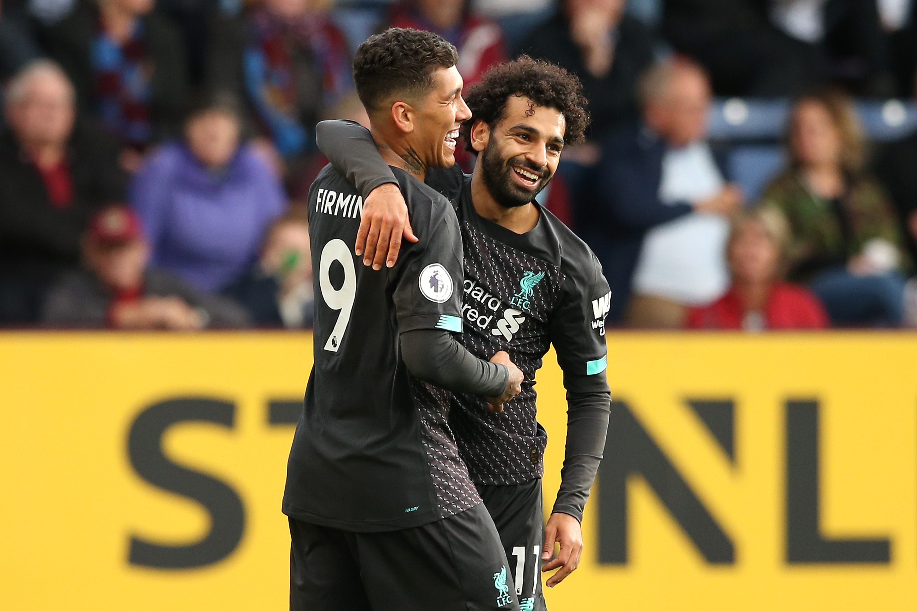 BURNLEY, ENGLAND - AUGUST 31: Roberto Firmino of Liverpool celebrates with teammate Mohamed Salah after scoring his team's third goal  during the Premier League match between Burnley FC and Liverpool FC at Turf Moor on August 31, 2019 in Burnley, United Kingdom. (Photo by Jan Kruger/Getty Images)