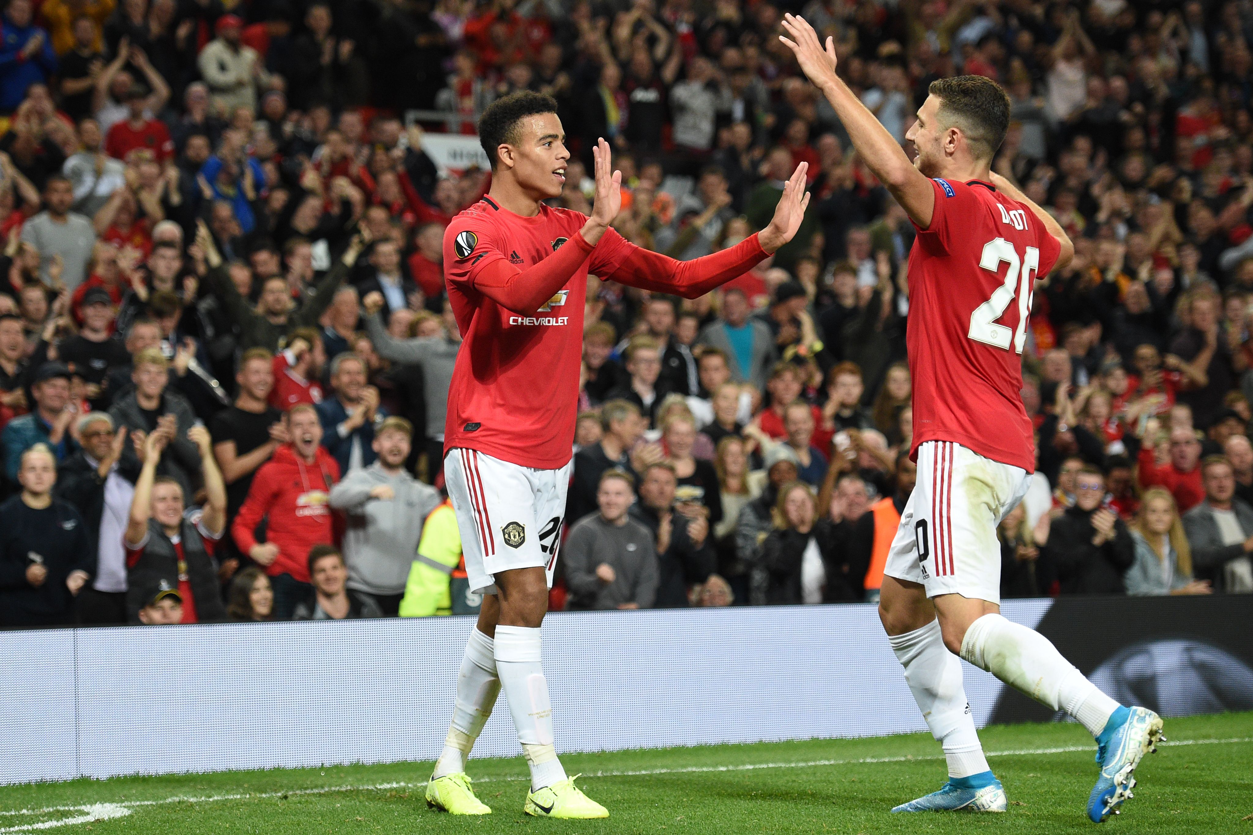 Manchester United's striker Mason Greenwood (L) celebrates with Manchester United's Portuguese defender Diogo Dalot (R) after scoring the opening goal of the UEFA Europa League Group L football match between Manchester United and Astana at Old Trafford in Manchester, north west England, on September 19, 2019. (Photo by Oli SCARFF / AFP)        (Photo credit should read OLI SCARFF/AFP/Getty Images)