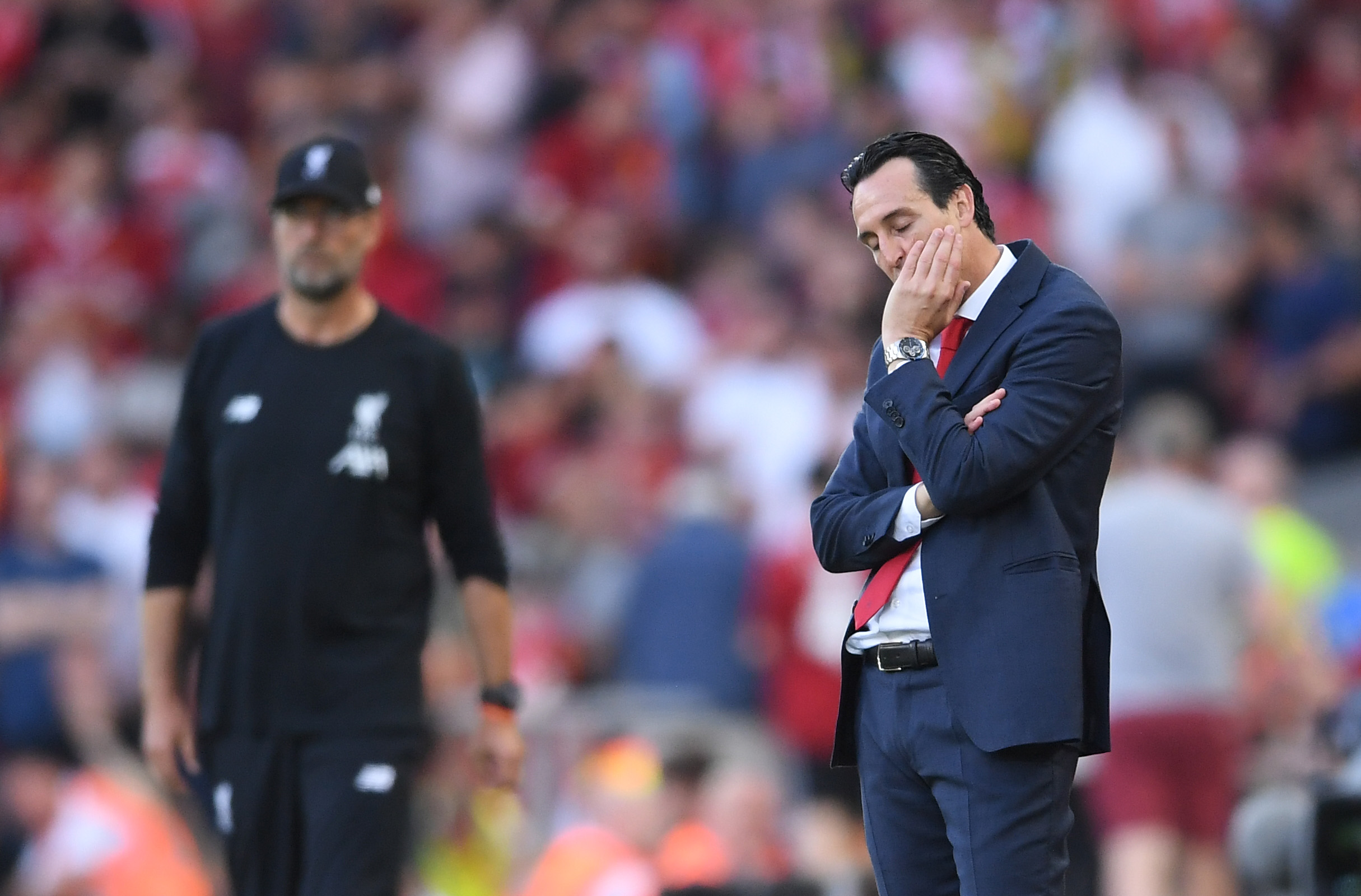 LIVERPOOL, ENGLAND - AUGUST 24: Unai Emery, Manager of Arsenal looks on in front of Jurgen Klopp of Liverpool during the Premier League match between Liverpool FC and Arsenal FC at Anfield on August 24, 2019 in Liverpool, United Kingdom. (Photo by Laurence Griffiths/Getty Images)
