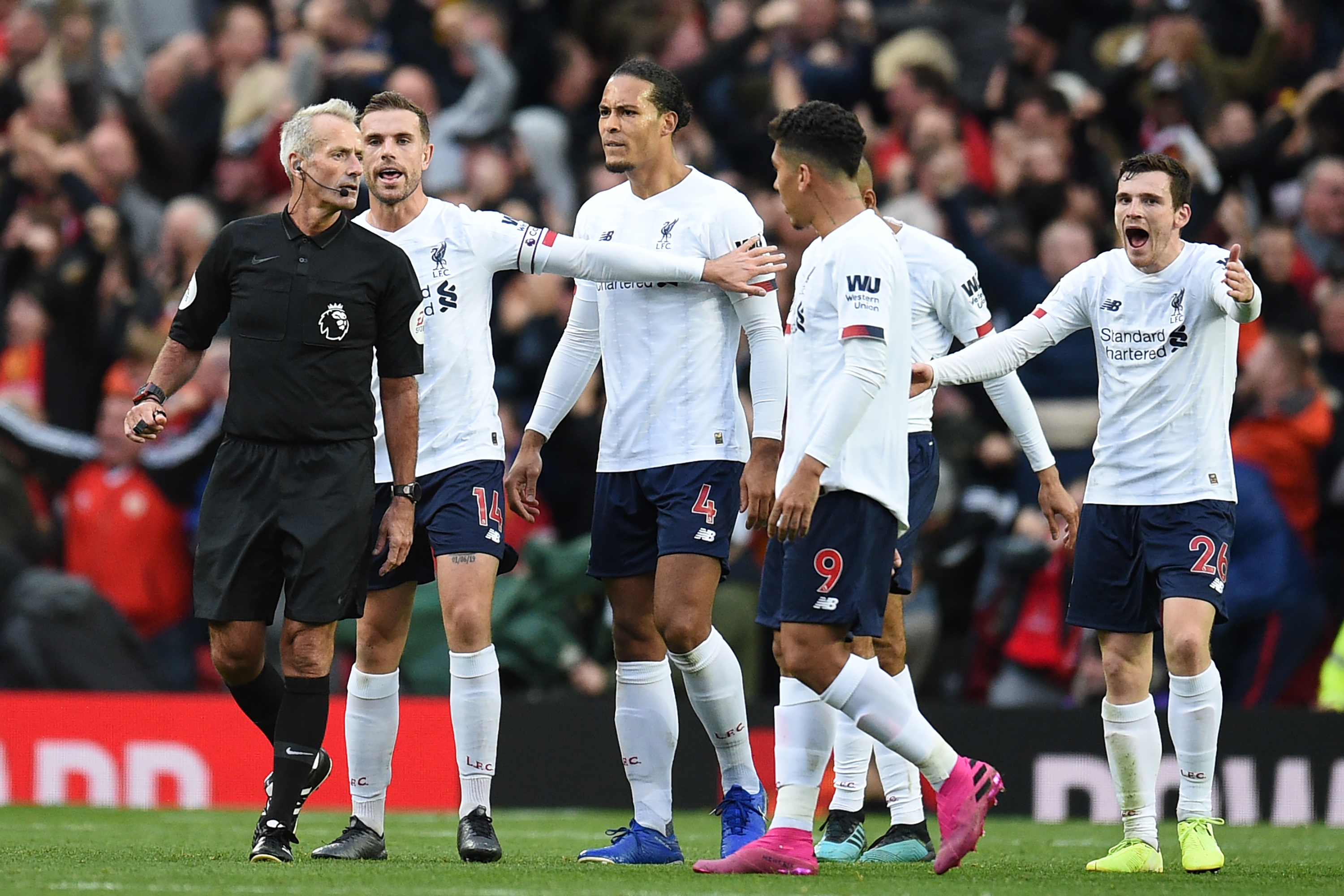 Liverpool players appeal to English referee Martin Atkinson (L) after he allows the opening goal despite a foul on Liverpool's Belgium striker Divock Origi in the build up, during the English Premier League football match between Manchester United and Liverpool at Old Trafford in Manchester, north west England, on October 20, 2019. (Photo by Oli SCARFF / AFP) / RESTRICTED TO EDITORIAL USE. No use with unauthorized audio, video, data, fixture lists, club/league logos or 'live' services. Online in-match use limited to 120 images. An additional 40 images may be used in extra time. No video emulation. Social media in-match use limited to 120 images. An additional 40 images may be used in extra time. No use in betting publications, games or single club/league/player publications. /  (Photo by OLI SCARFF/AFP via Getty Images)