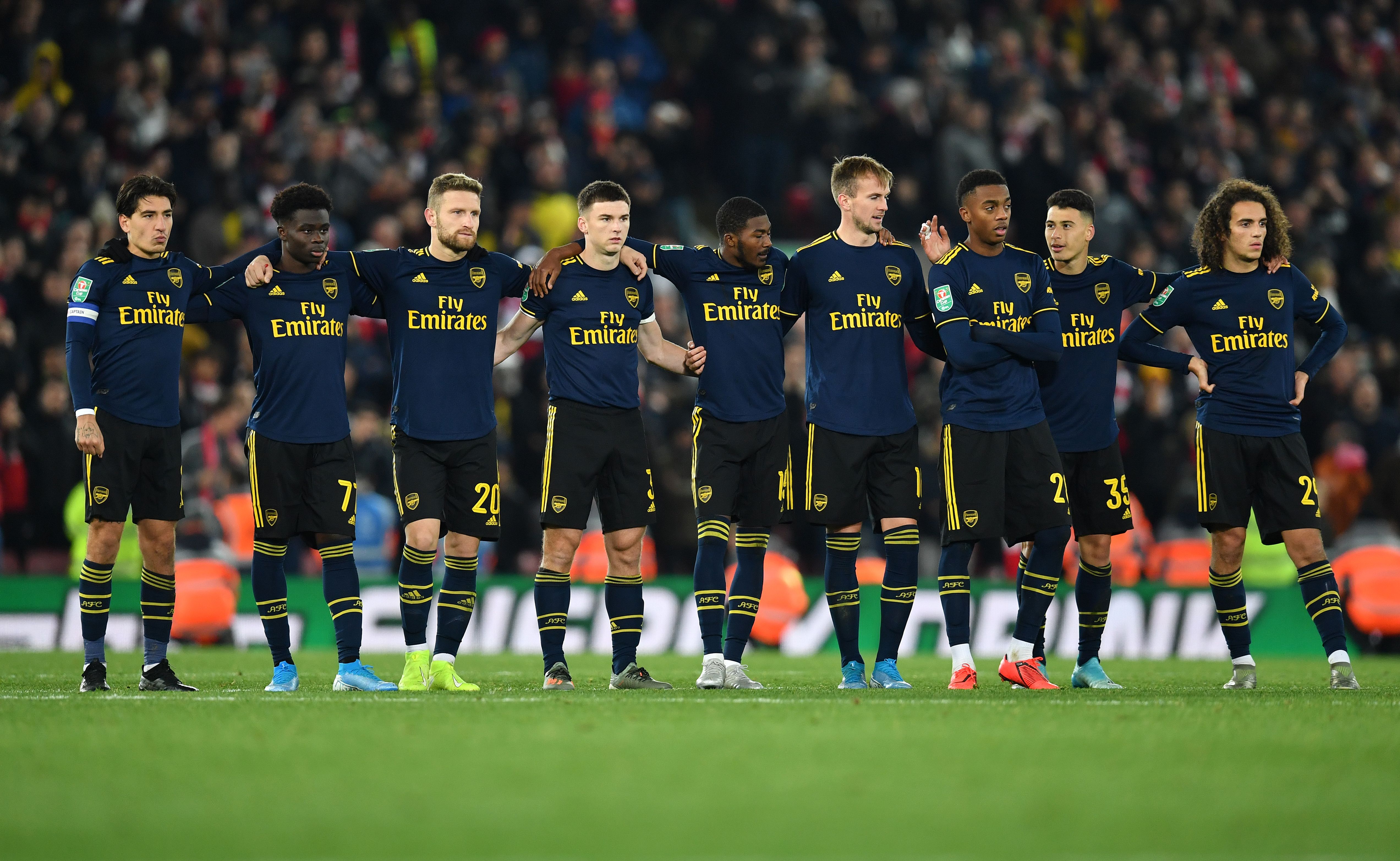 Arsenal's Spanish defender Hector Bellerin (L) stands with teammates as they wait to take their penalties in a penalty shoot-out during the English League Cup fourth round football match between Liverpool and Arsenal at Anfield in Liverpool, north west England on October 30, 2019. - Liverpool won the match after winning the penalty shoot out, following a 5-5 draw in the match. (Photo by Paul ELLIS / AFP) / RESTRICTED TO EDITORIAL USE. No use with unauthorized audio, video, data, fixture lists, club/league logos or 'live' services. Online in-match use limited to 75 images, no video emulation. No use in betting, games or single club/league/player publications. /  (Photo by PAUL ELLIS/AFP via Getty Images)