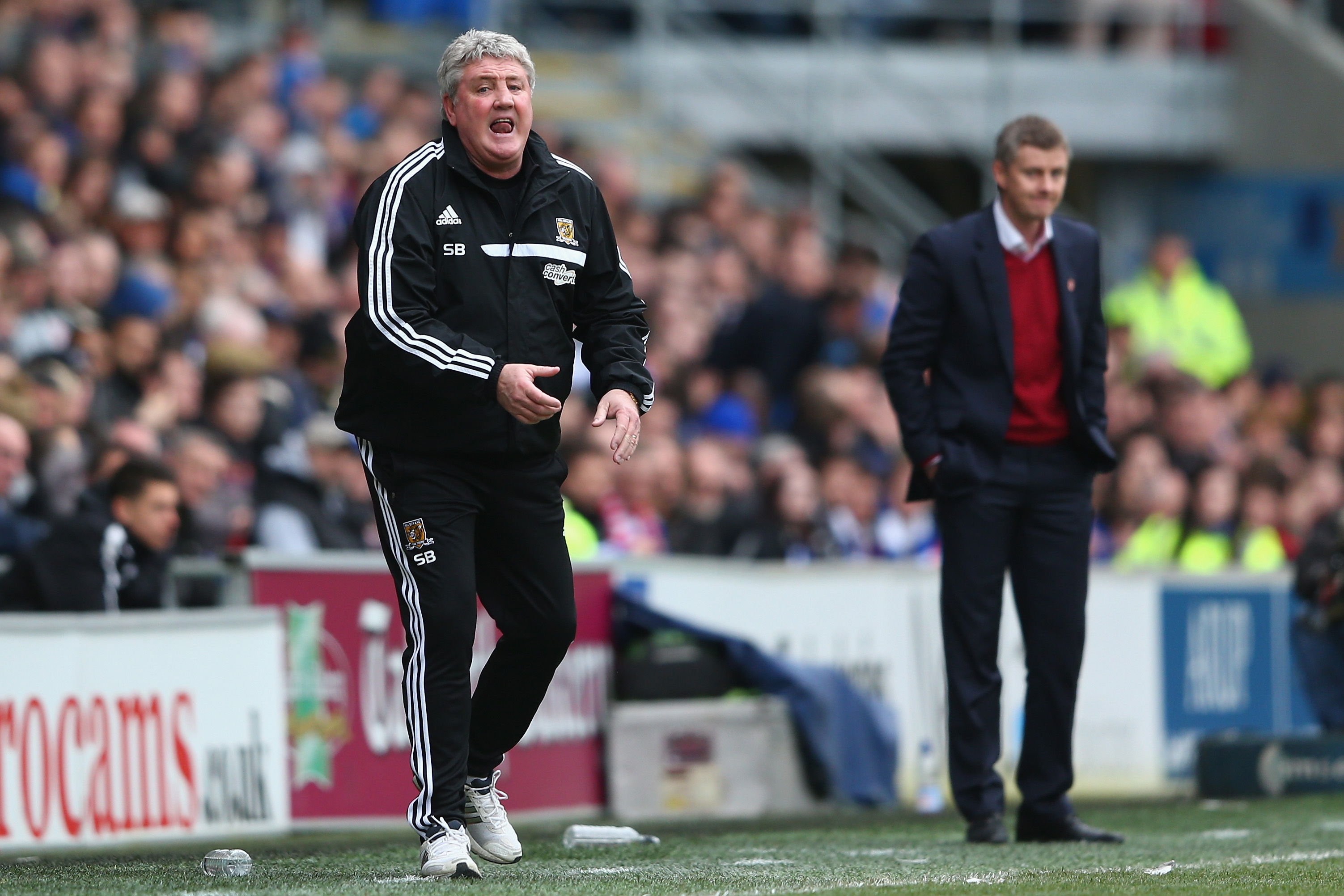 CARDIFF, WALES - FEBRUARY 22:  Steve Bruce (L) the manager of Hull City shouts instructions as Ole Gunnar Solskjaer (R) the manager of Cardiff City looks on during the Barclays Premier League match between Cardiff City and Hull City at the Cardiff City Stadium on February 22, 2014 in Cardiff, Wales.  (Photo by Michael Steele/Getty Images)