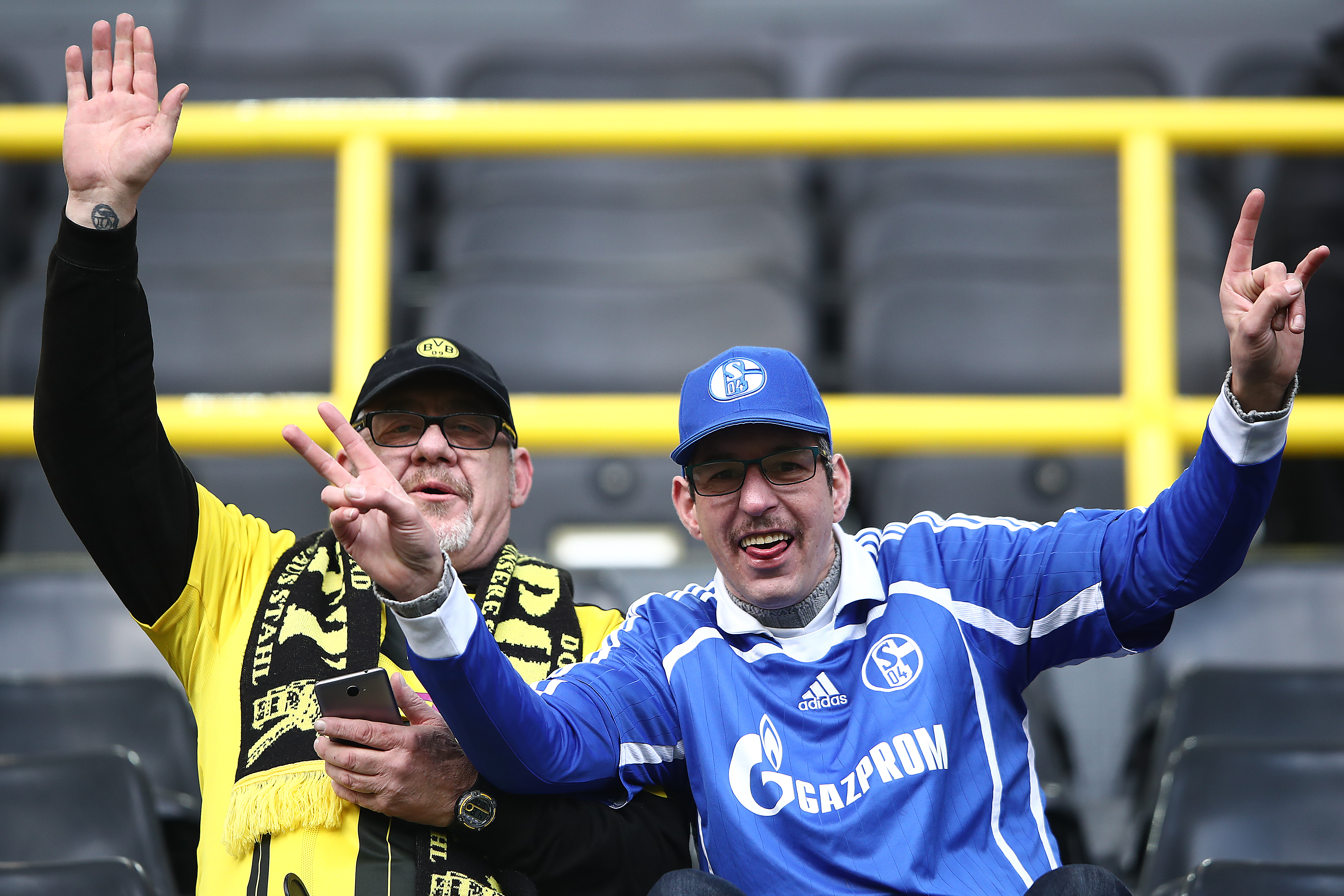 DORTMUND, GERMANY - NOVEMBER 25: Supporters of both Schalke (r) and Dortmund sit happily next to each other and wave and smile, before the Bundesliga match between Borussia Dortmund and FC Schalke 04 at Signal Iduna Park on November 25, 2017 in Dortmund, Germany. (Photo by Alex Grimm/Bongarts/Getty Images)