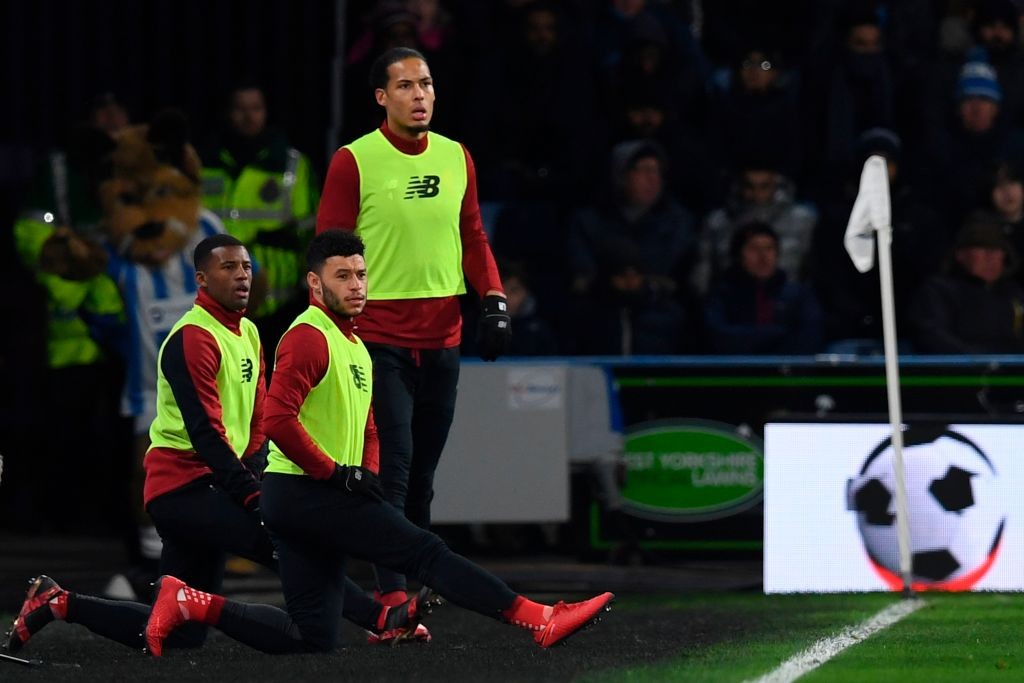 Liverpool's Dutch midfielder Georginio Wijnaldum (L), Liverpool's English midfielder Alex Oxlade-Chamberlain (C) and Liverpool's Dutch defender Virgil van Dijk (R) warm up on the touchline during the English Premier League football match between Huddersfield Town and Liverpool at the John Smith's stadium in Huddersfield, northern England on January 30, 2018. / AFP PHOTO / Paul ELLIS / RESTRICTED TO EDITORIAL USE. No use with unauthorized audio, video, data, fixture lists, club/league logos or 'live' services. Online in-match use limited to 75 images, no video emulation. No use in betting, games or single club/league/player publications. / (Photo credit should read PAUL ELLIS/AFP via Getty Images)