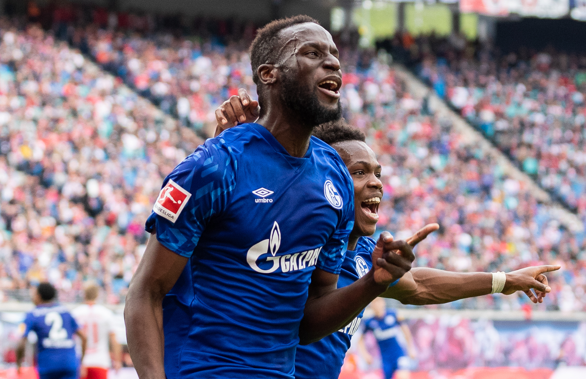 LEIPZIG, GERMANY - SEPTEMBER 28: Salif Sane of FC Schalke 04 celebrates with teammate Rabbi Matondo Baba of VfL Wolfsburg after scoring his team's first goal during the Bundesliga match between RB Leipzig and FC Schalke 04 at Red Bull Arena on September 28, 2019 in Leipzig, Germany. (Photo by Boris Streubel/Bongarts/Getty Images)