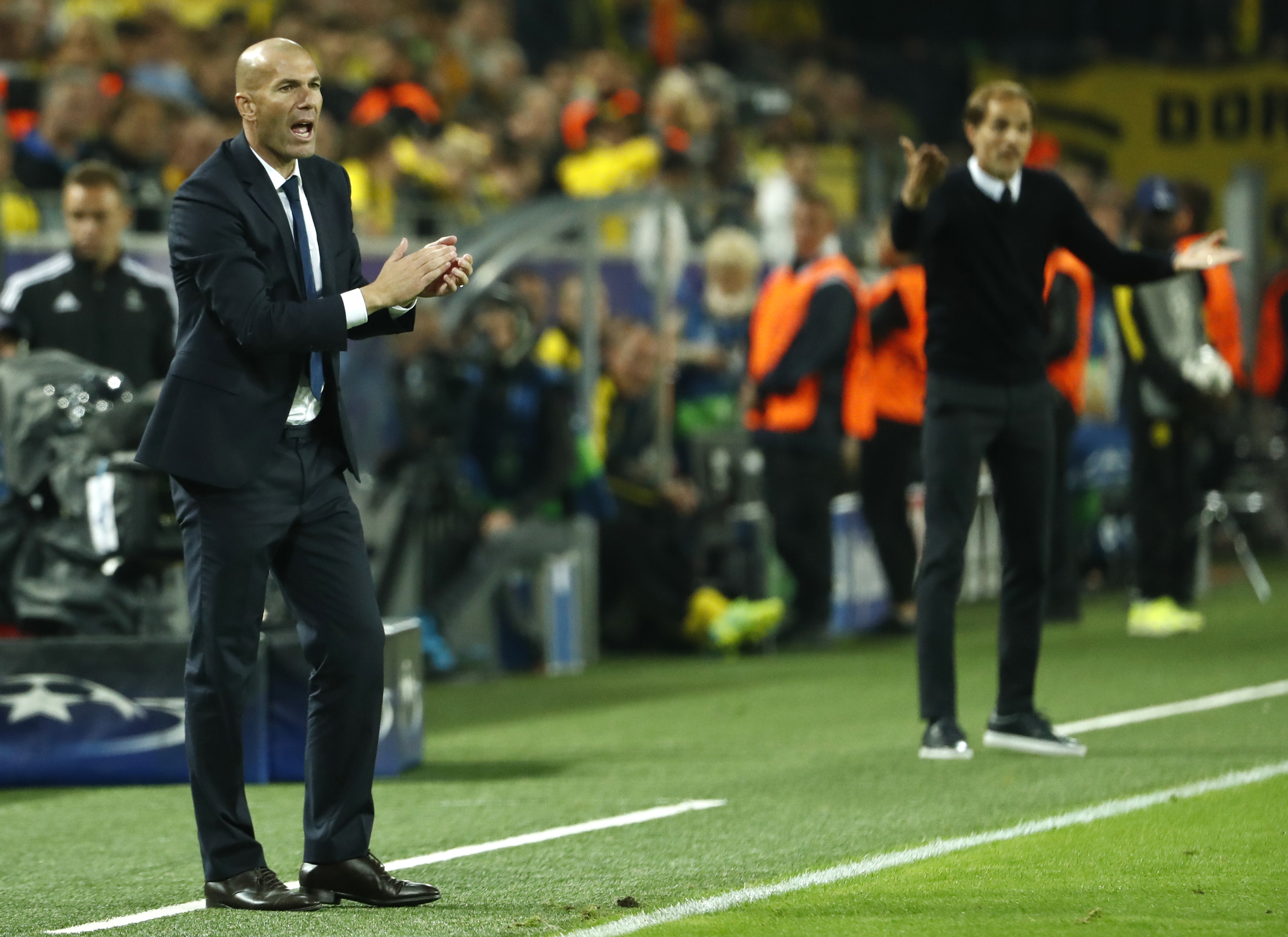 Real Madrid's French coach Zinedine Zidane (C) and Dortmund's head coach Thomas Tuchel (R) react during the UEFA Champions League first leg football match between Borussia Dortmund and Real Madrid at BVB stadium in Dortmund, on September 27, 2016. / AFP / Odd ANDERSEN        (Photo credit should read ODD ANDERSEN/AFP via Getty Images)