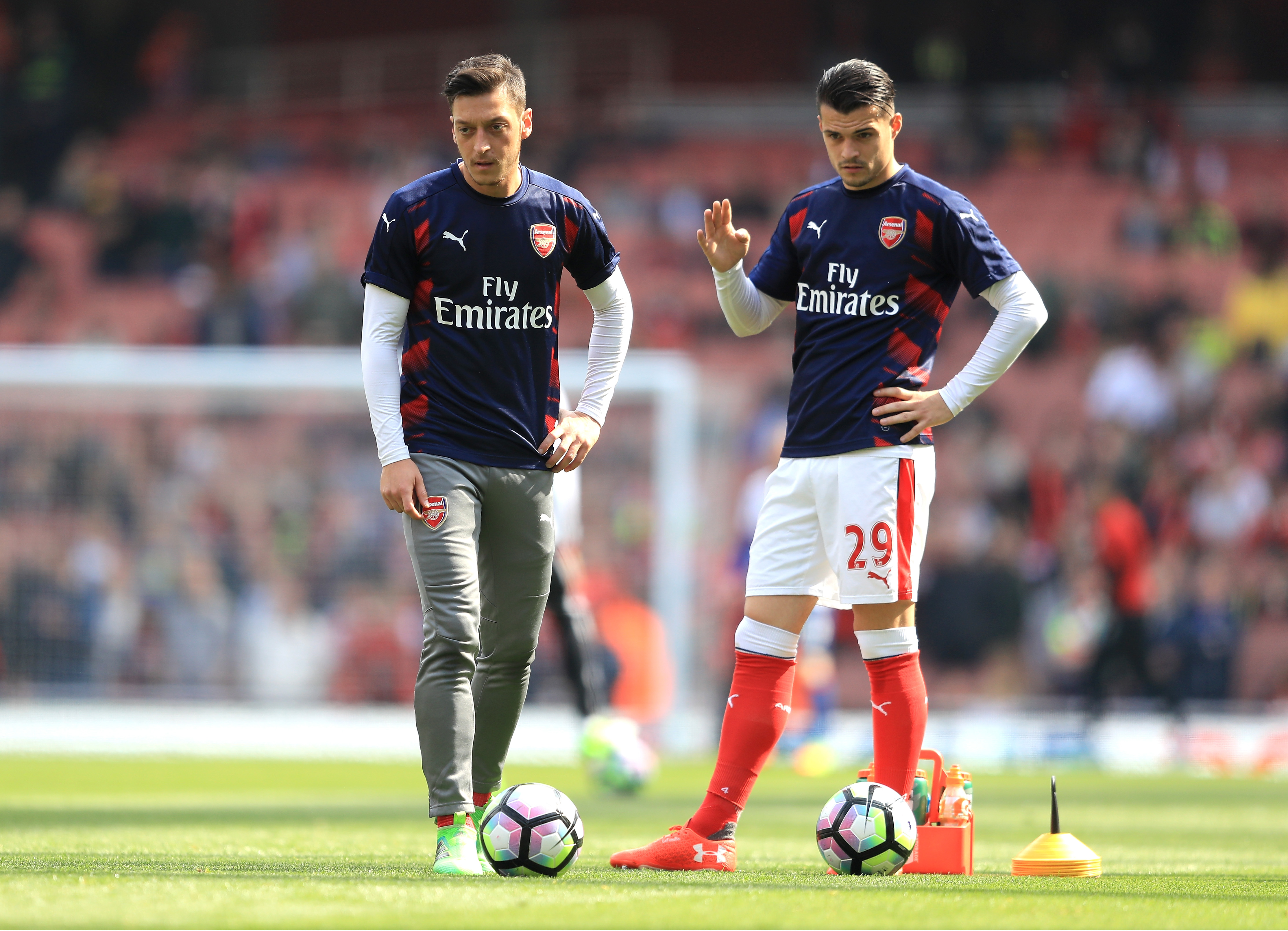 LONDON, ENGLAND - MAY 07: Mesut Ozil of Arsenal and Granit Xhaka of Arsenal speak while they are warm up prior to the Premier League match between Arsenal and Manchester United at the Emirates Stadium on May 7, 2017 in London, England.  (Photo by Richard Heathcote/Getty Images)