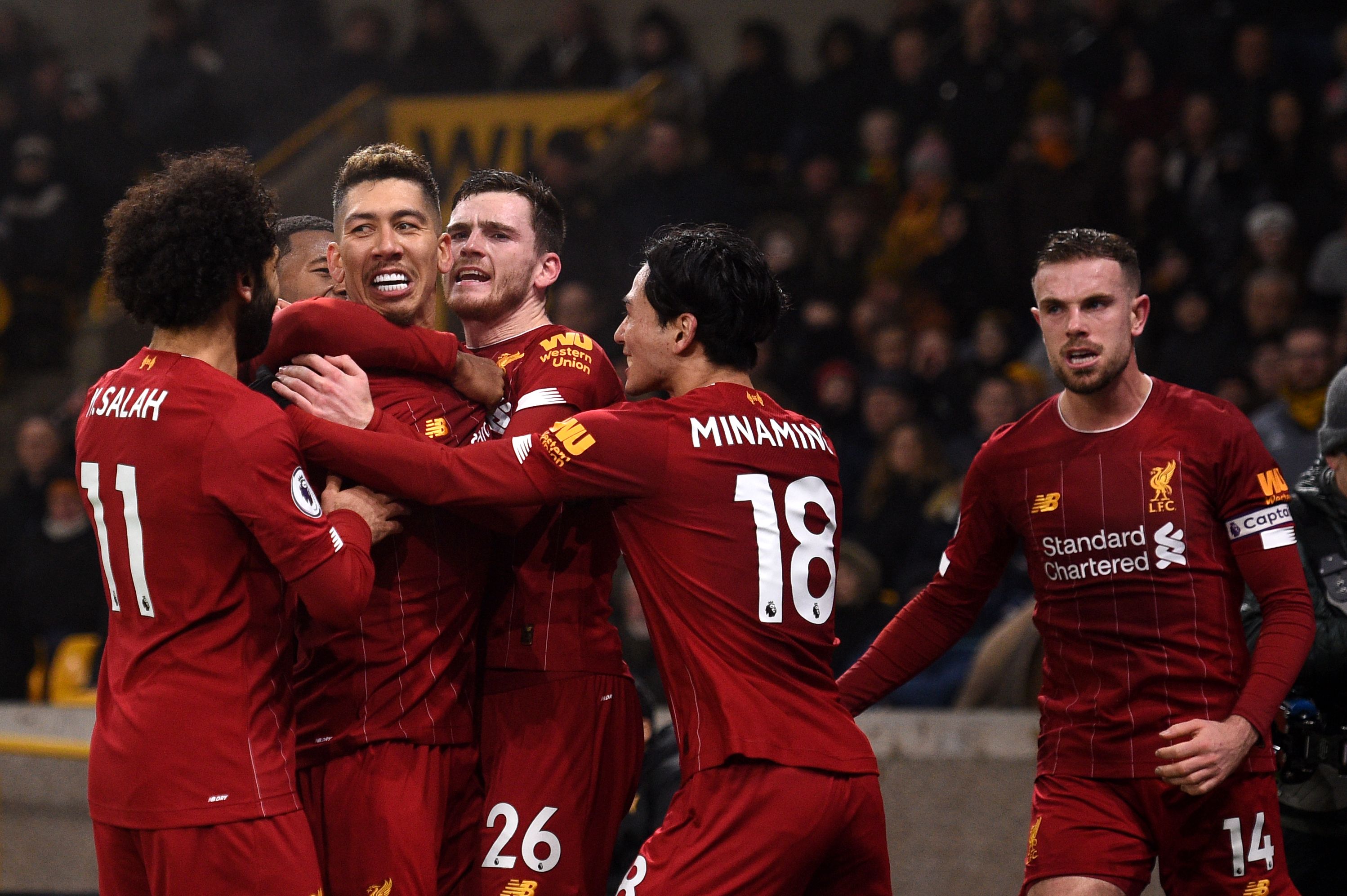 Liverpool's Brazilian midfielder Roberto Firmino (CL)  celebrates with teammates after he scores the team's second goal during the English Premier League football match between Wolverhampton Wanderers and Liverpool at the Molineux stadium in Wolverhampton, central England on January 23, 2020. (Photo by Oli SCARFF / AFP) / RESTRICTED TO EDITORIAL USE. No use with unauthorized audio, video, data, fixture lists, club/league logos or 'live' services. Online in-match use limited to 120 images. An additional 40 images may be used in extra time. No video emulation. Social media in-match use limited to 120 images. An additional 40 images may be used in extra time. No use in betting publications, games or single club/league/player publications. /  (Photo by OLI SCARFF/AFP via Getty Images)