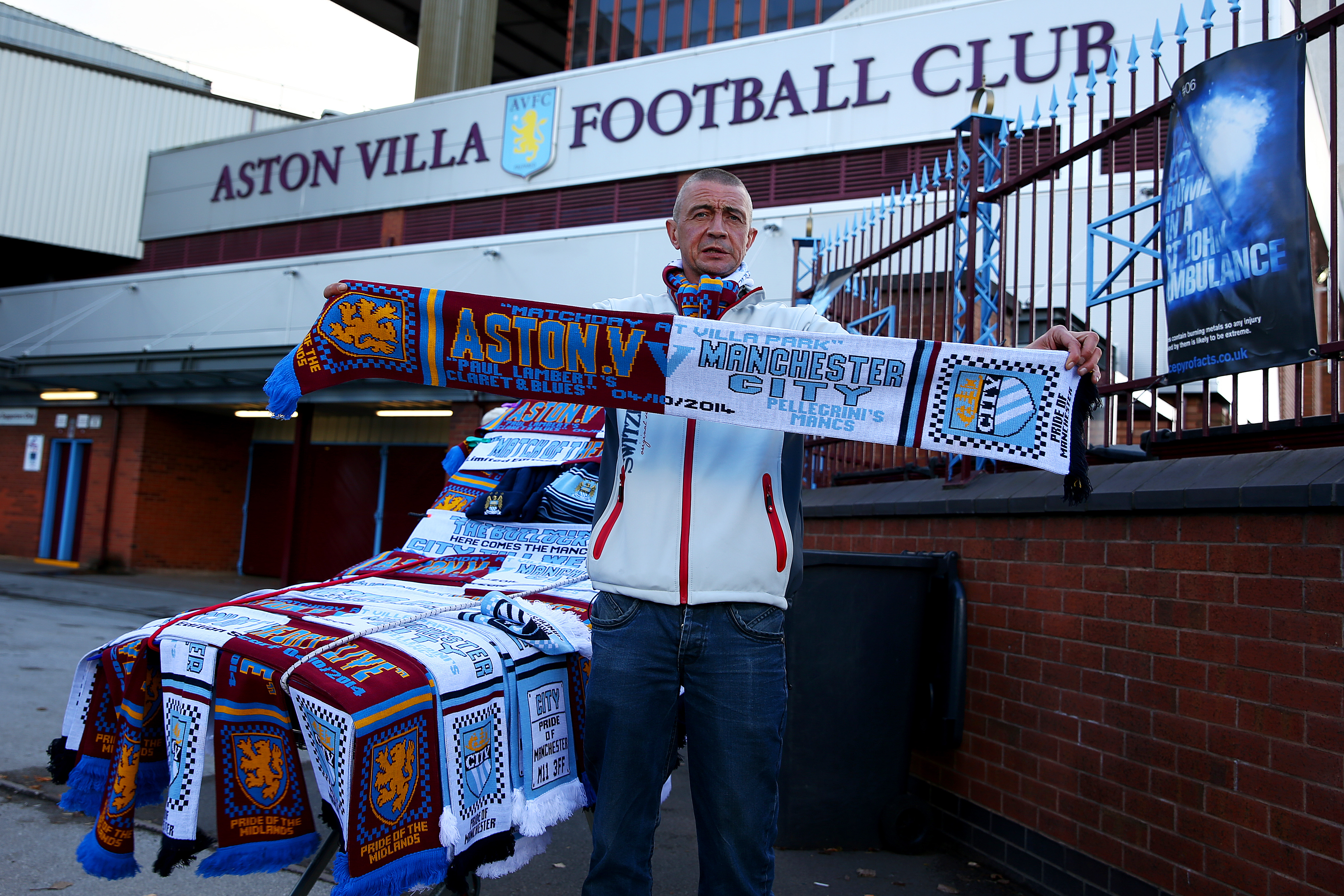 BIRMINGHAM, ENGLAND - OCTOBER 04:  A vendor poses with scarves for sale at a stall outside the stadium before the Barclays Premier League match between Aston Villa and Manchester City at Villa Park on October 4, 2014 in Birmingham, England.  (Photo by Ian Walton/Getty Images)