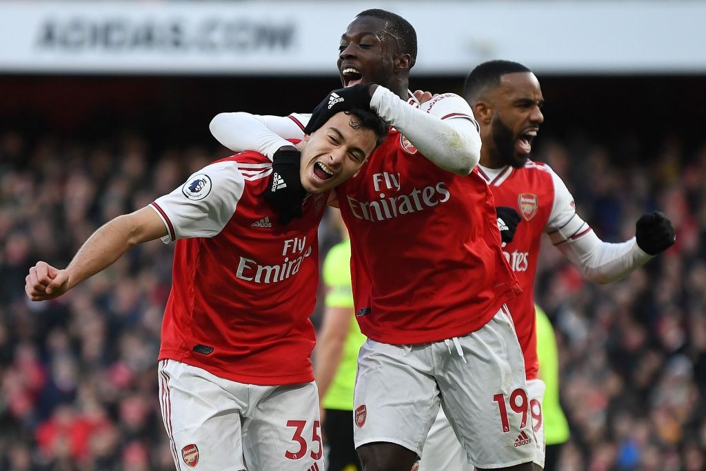Arsenal's Brazilian striker Gabriel Martinelli (L) celebrates scoring the opening goal with Arsenal's French-born Ivorian midfielder Nicolas Pepe (C) and Arsenal's French striker Alexandre Lacazette during the English Premier League football match between Arsenal and Sheffield United at the Emirates Stadium in London on January 18, 2020. (Photo by DANIEL LEAL-OLIVAS / AFP) / RESTRICTED TO EDITORIAL USE. No use with unauthorized audio, video, data, fixture lists, club/league logos or 'live' services. Online in-match use limited to 120 images. An additional 40 images may be used in extra time. No video emulation. Social media in-match use limited to 120 images. An additional 40 images may be used in extra time. No use in betting publications, games or single club/league/player publications. / (Photo by DANIEL LEAL-OLIVAS/AFP via Getty Images)
