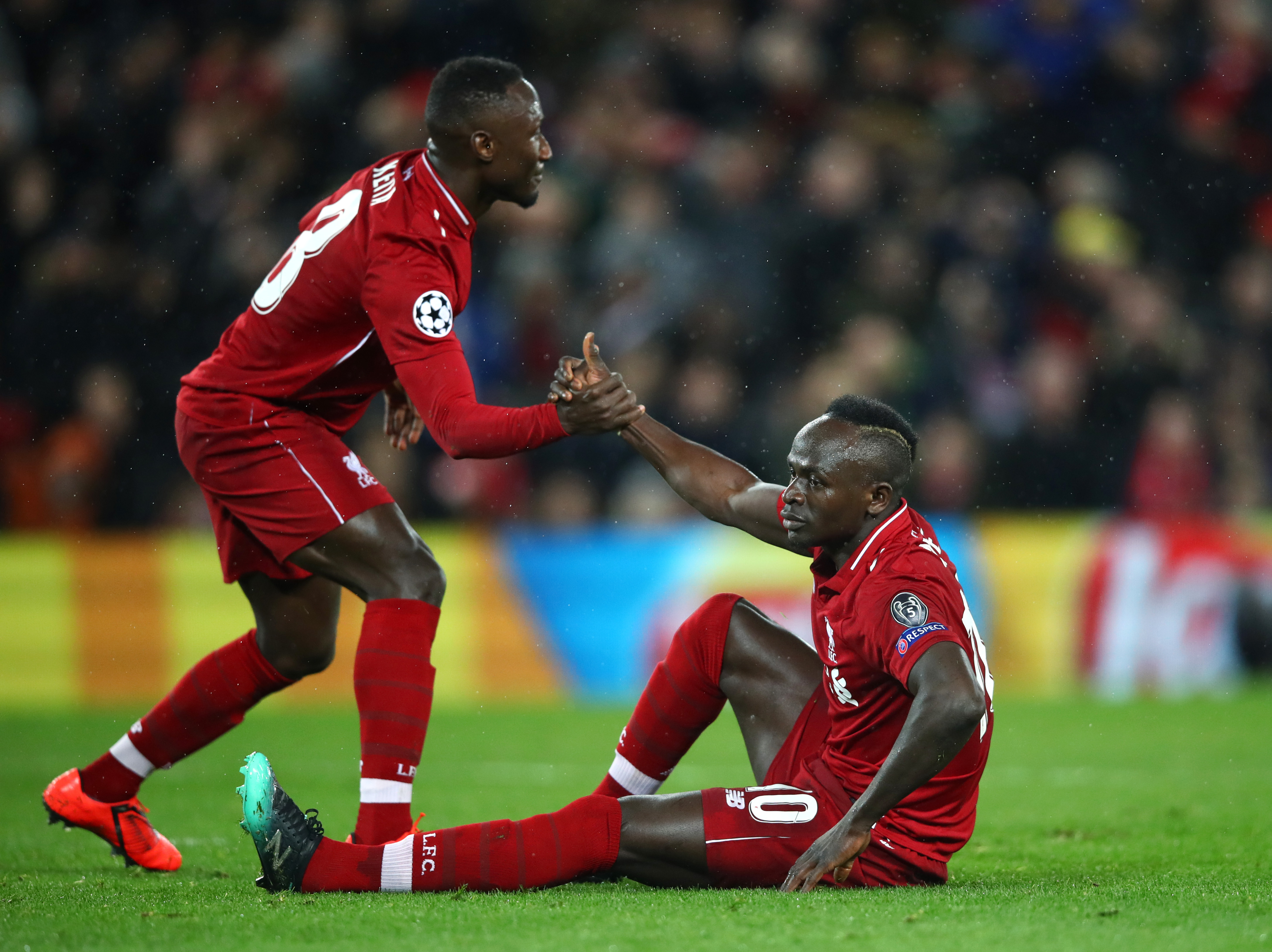 LIVERPOOL, ENGLAND - FEBRUARY 19:  Sadio Mane of Liverpool is assisted by team mate Naby Keita during the UEFA Champions League Round of 16 First Leg match between Liverpool and FC Bayern Muenchen at Anfield on February 19, 2019 in Liverpool, England. (Photo by Clive Brunskill/Getty Images)