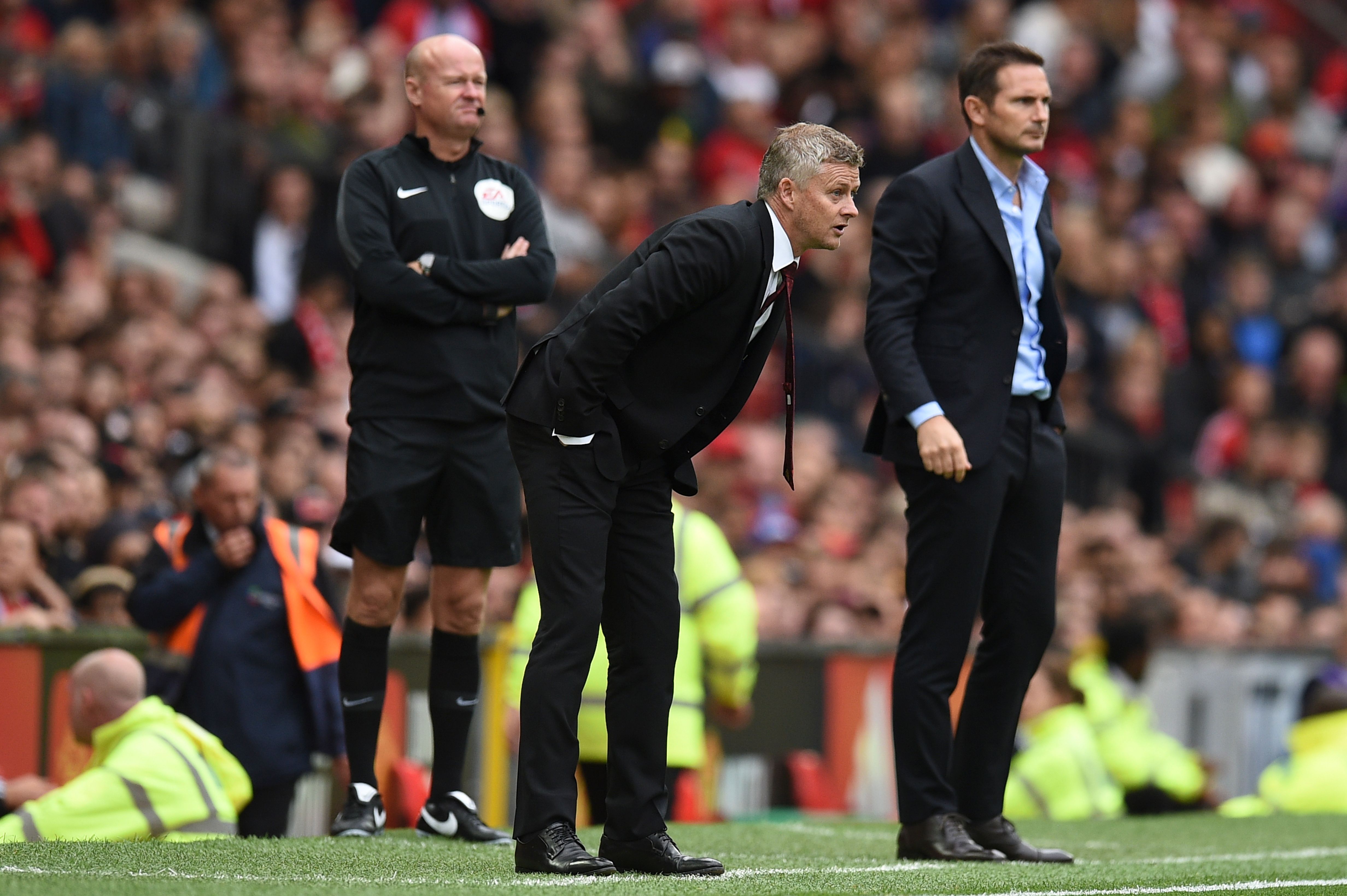 Manchester United's Norwegian manager Ole Gunnar Solskjaer (C) and Chelsea's English head coach Frank Lampard (R) look on during the English Premier League football match between Manchester United and Chelsea at Old Trafford in Manchester, north west England, on August 11, 2019. (Photo by Oli SCARFF / AFP) / RESTRICTED TO EDITORIAL USE. No use with unauthorized audio, video, data, fixture lists, club/league logos or 'live' services. Online in-match use limited to 120 images. An additional 40 images may be used in extra time. No video emulation. Social media in-match use limited to 120 images. An additional 40 images may be used in extra time. No use in betting publications, games or single club/league/player publications. /         (Photo credit should read OLI SCARFF/AFP via Getty Images)