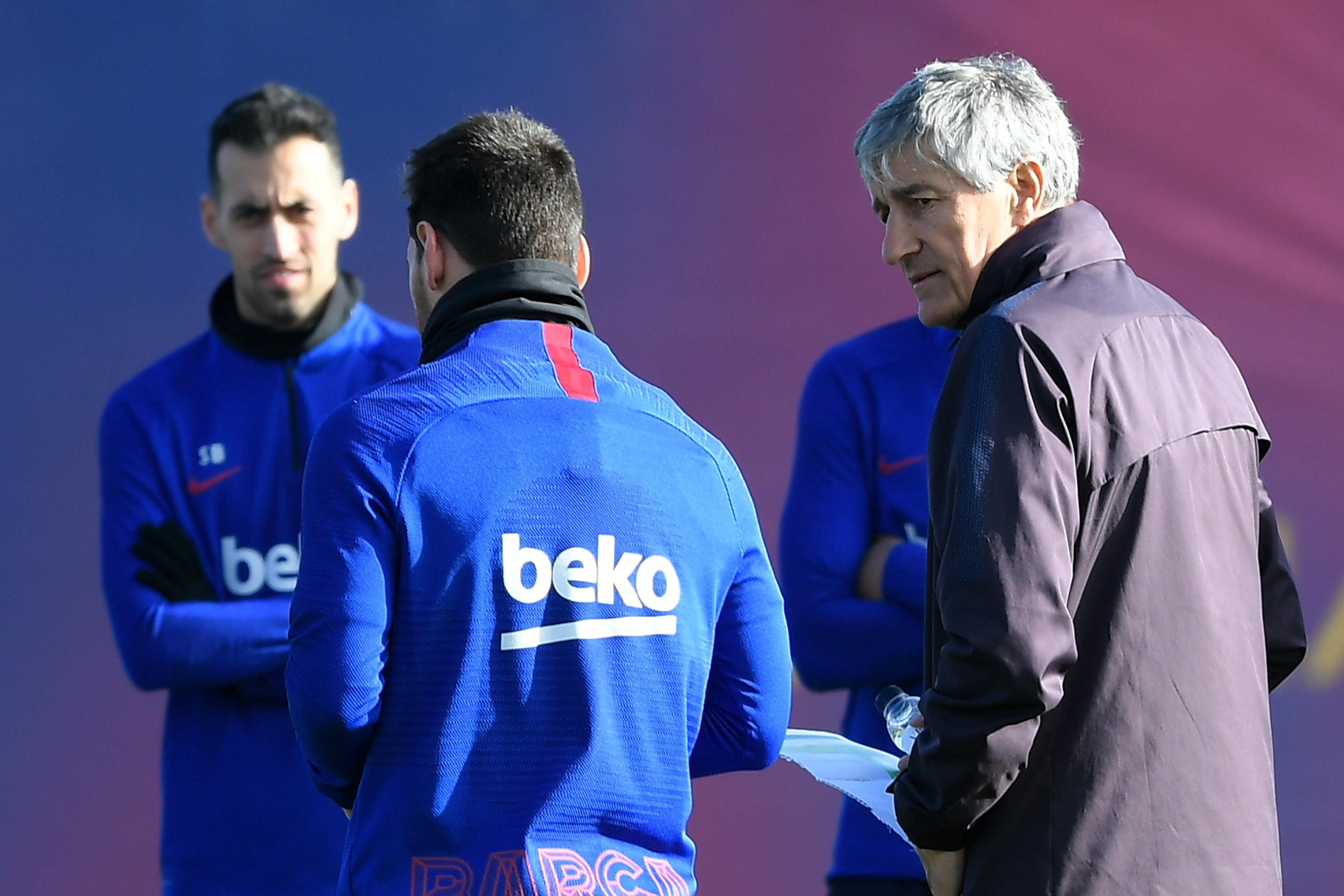 Barcelona's new coach, Spaniard Quique Setien (R), looks at Barcelona's Argentine forward Lionel Messi beside Barcelona's Spanish midfielder Sergio Busquets (L) during a training session at the Joan Gamper Sports City training ground in Sant Joan Despi on January 18, 2020. (Photo by LLUIS GENE / AFP) (Photo by LLUIS GENE/AFP via Getty Images)