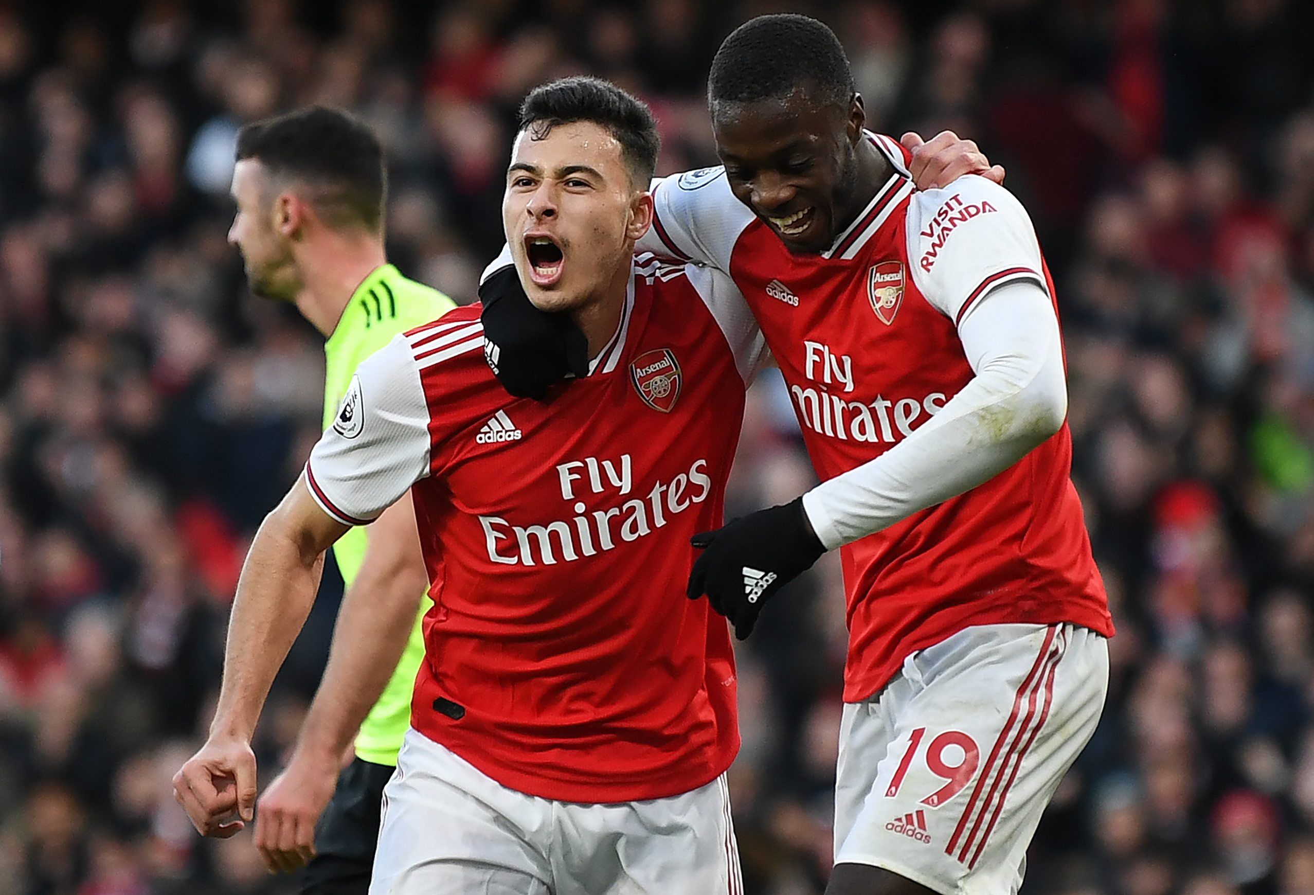 Arsenal's Brazilian striker Gabriel Martinelli (C) celebrates scoring the opening goal with Arsenal's French-born Ivorian midfielder Nicolas Pepe during the English Premier League football match between Arsenal and Sheffield United at the Emirates Stadium in London on January 18, 2020. (Photo by DANIEL LEAL-OLIVAS / AFP) / RESTRICTED TO EDITORIAL USE. No use with unauthorized audio, video, data, fixture lists, club/league logos or 'live' services. Online in-match use limited to 120 images. An additional 40 images may be used in extra time. No video emulation. Social media in-match use limited to 120 images. An additional 40 images may be used in extra time. No use in betting publications, games or single club/league/player publications. /  (Photo by DANIEL LEAL-OLIVAS/AFP via Getty Images)