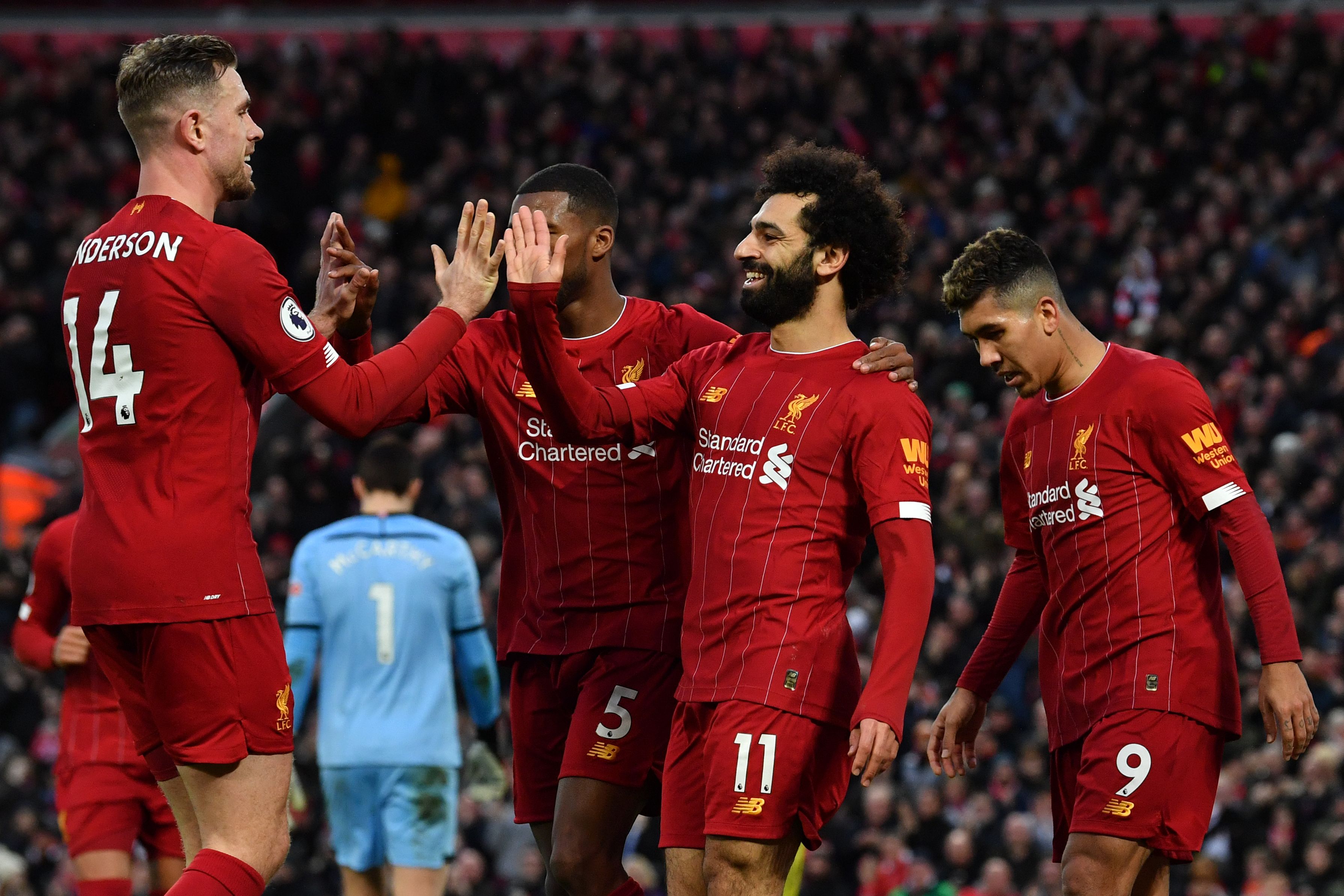 Liverpool's Egyptian midfielder Mohamed Salah (C) celebrates with teammates after scoring his team's third goal during the English Premier League football match between Liverpool and Southampton at Anfield in Liverpool, north west England on February 1, 2020. (Photo by Paul ELLIS / AFP) / RESTRICTED TO EDITORIAL USE. No use with unauthorized audio, video, data, fixture lists, club/league logos or 'live' services. Online in-match use limited to 120 images. An additional 40 images may be used in extra time. No video emulation. Social media in-match use limited to 120 images. An additional 40 images may be used in extra time. No use in betting publications, games or single club/league/player publications. /  (Photo by PAUL ELLIS/AFP via Getty Images)